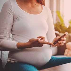Pregnant woman checking her diabetes level with a glucose pen, highlighting the link between diet and female fertility